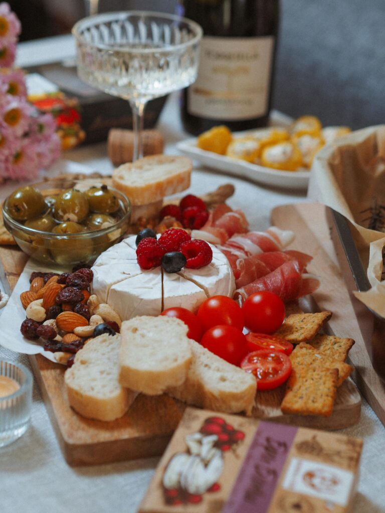 Delicious charcuterie board featuring cheese, ham, olives, and wine, perfect for gatherings.